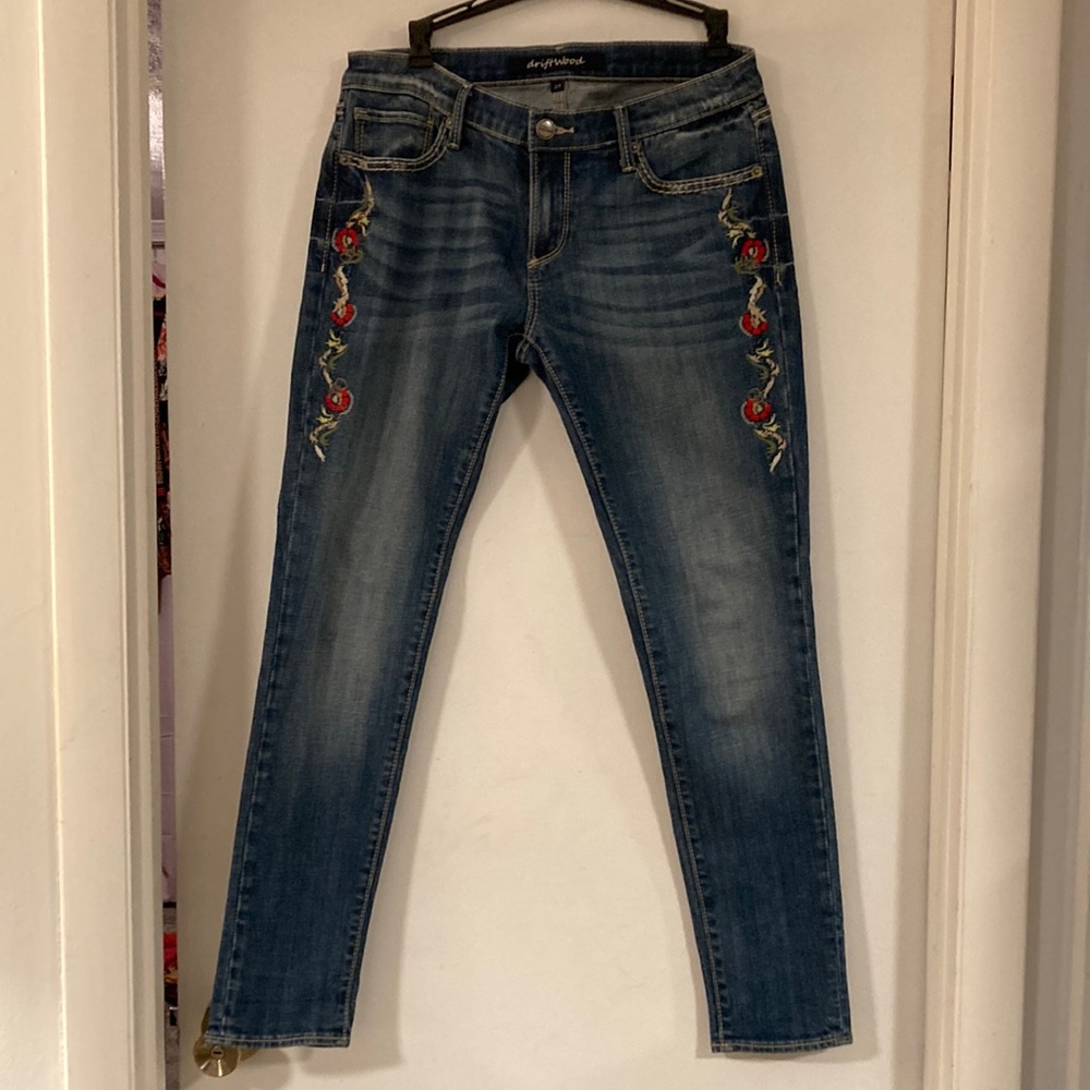 Driftwood size 29 jeans with embroidered flowers on the side of each leg.